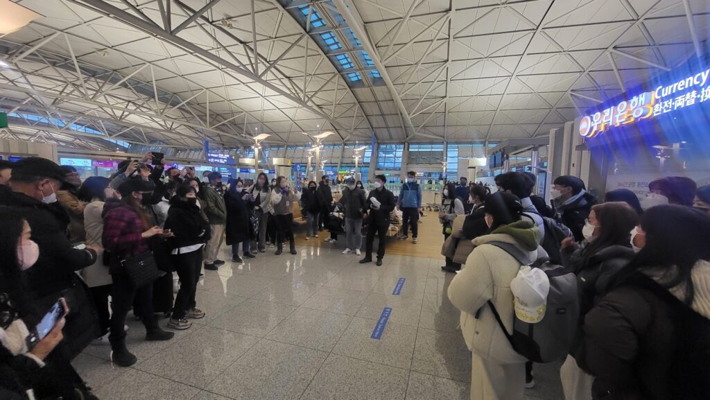 캐나다 유학 출국 전, 인천공항에서 인솔자의 설명을 집중해서 듣는 모습