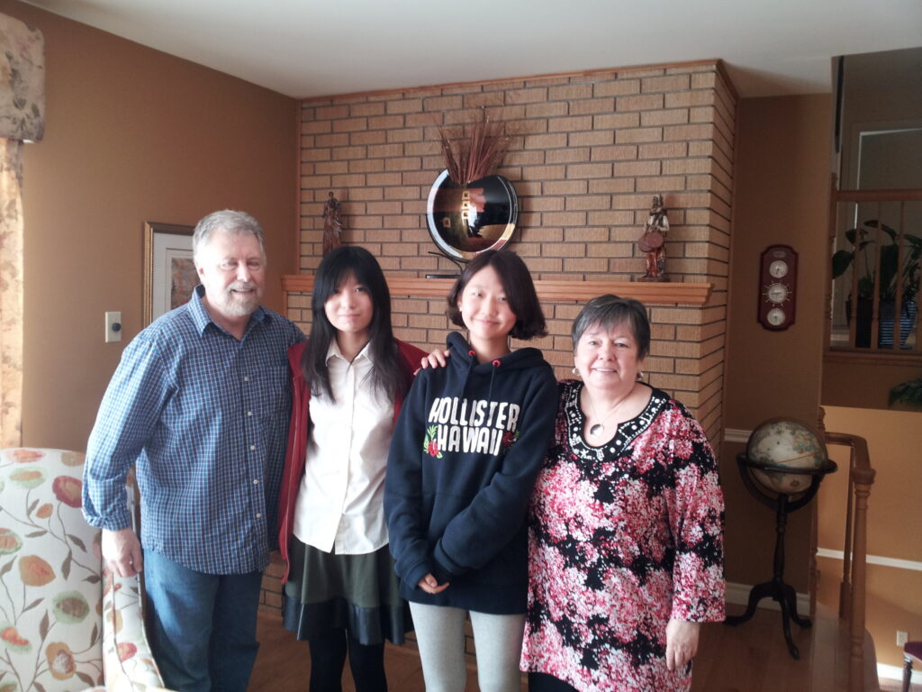 캐나다 노바스코샤 조기유학 학생과 홈스테이 가족이 함께 환하게 웃고 있는 모습